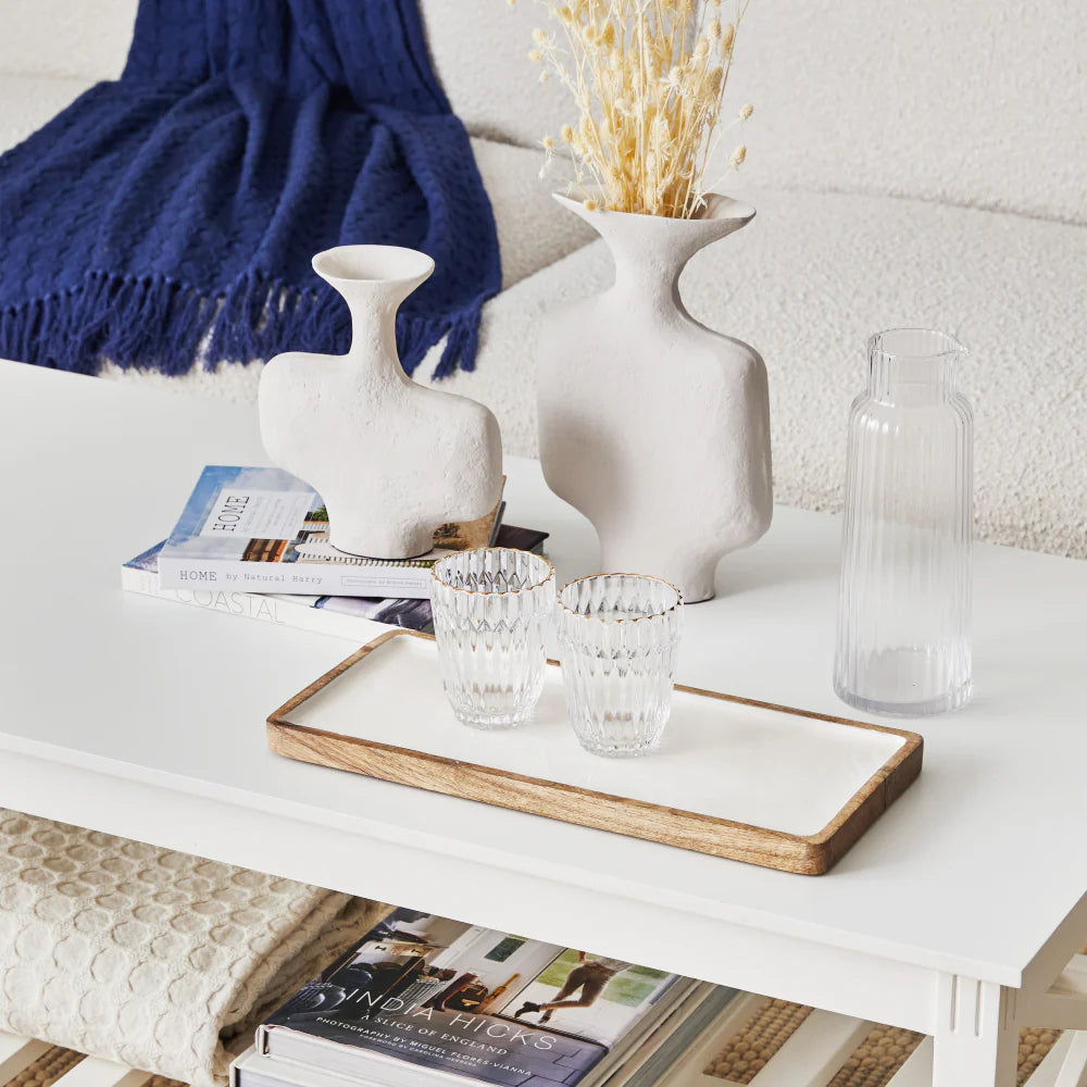 Decorative items on a coffee table including vases, glasses, and books.