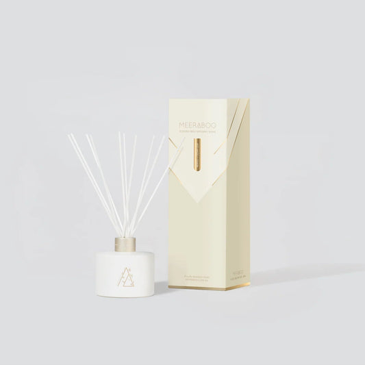 Diffuser bottle with reeds and packaging on a light gray background