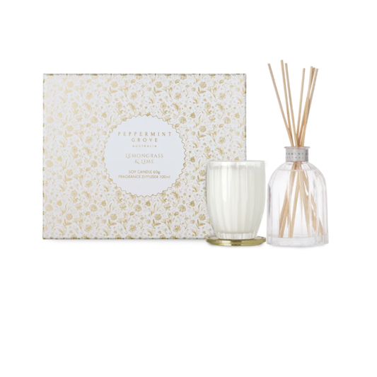 A Peppermint Grove reed diffuser set by Fragrance Grove, featuring a white soy candle in a clear glass jar with a gold base, a clear glass reed diffuser bottle with natural reeds, and the decorative white and gold floral-patterned gift box.