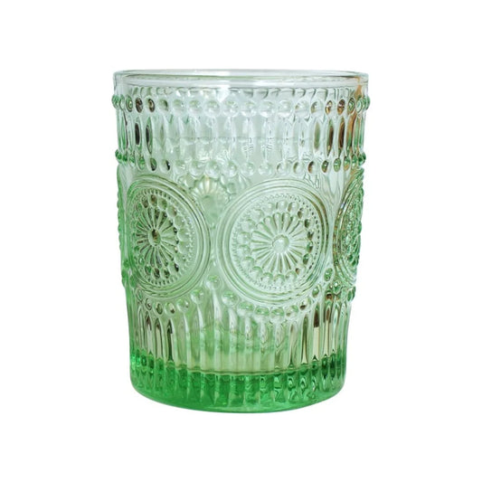 A clear glass tumbler with a green gradient and embossed circular medallion patterns, shown on a plain white background.