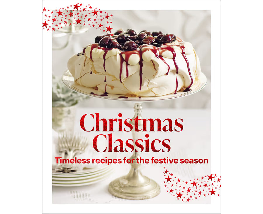 A cookbook cover titled "Christmas Classics" with the subtitle "Timeless recipes for the festive season." The cover features a decorated meringue cake on a silver stand, with red starburst accents in the corners.